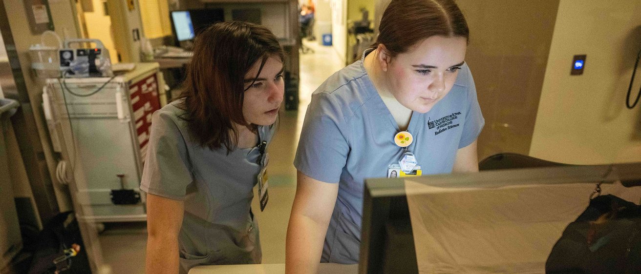 Two tech students looking at a computer screen