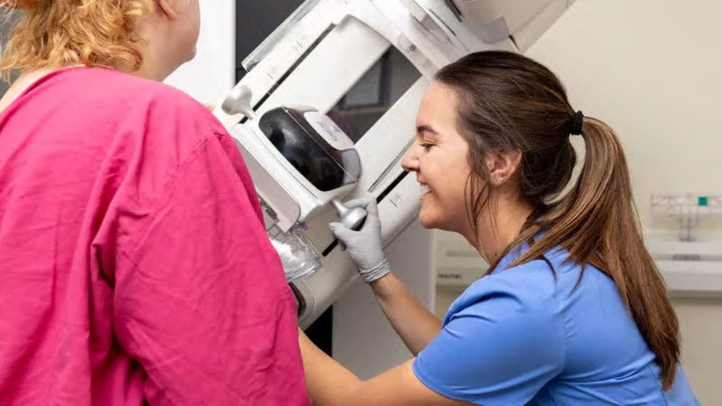 Rad tech performing mammography on patient